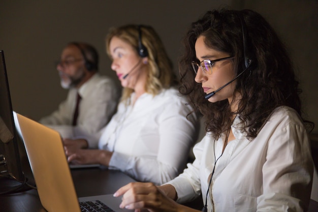 Equipe de suporte utilizando computadores e headsets